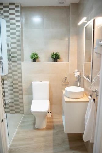 a bathroom with a toilet and a sink at Torneo 48 Suite in Seville