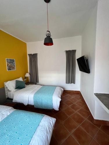two beds in a hotel room with at Le relais des sables in Tatta