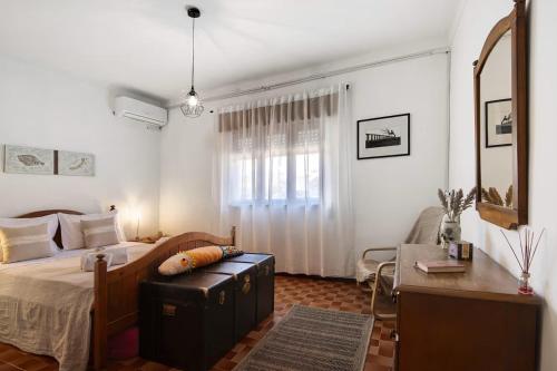 een slaapkamer met een bed, een stoel en een bureau bij Casa Maria Beatriz in Manta Rota