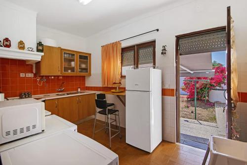 a kitchen with a white refrigerator and a window at Casa Maria Beatriz in Manta Rota