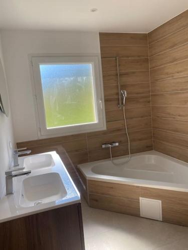 une salle de bain avec une baignoire et un lavabo et une baignoire dans l'établissement Villa de charme à la montagne, à Trescléoux