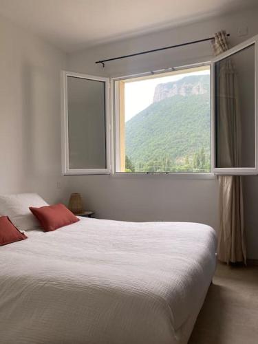 une chambre avec un grand lit et une fenêtre dans l'établissement Villa de charme à la montagne, à Trescléoux