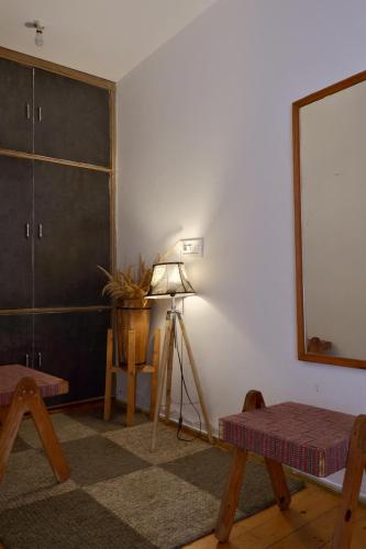 a room with a lamp and a table and a mirror at Utopia Hostels Dharamkot Mcleodganj in Dharamshala