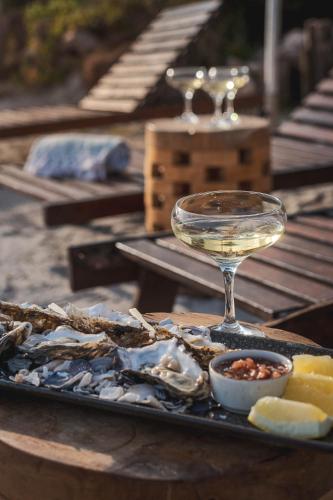 a plate of oysters and a glass of white wine at Blue Bay Lodge in Saldanha