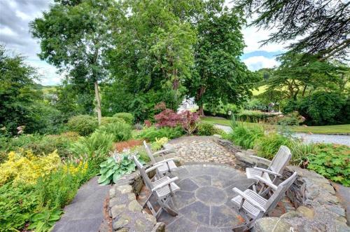 a group of chairs sitting on a stone patio at The Old Rectory Bed and Breakfast in Ruthin