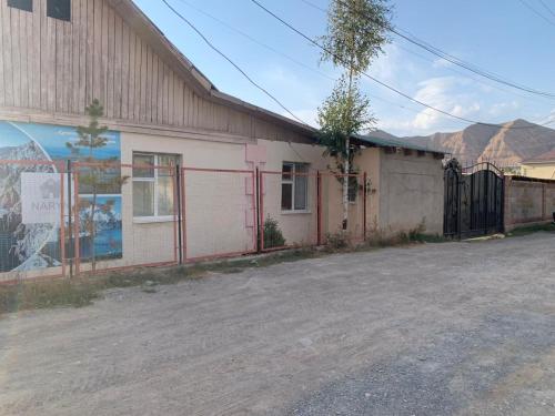 an old building with a fence in front of it at Naryn Guest House in Naryn