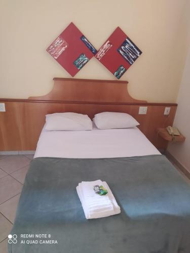 a hotel room with a bed with a towel on it at Pindorama Golden Plaza Hotel - Pindorama SP in Catanduva