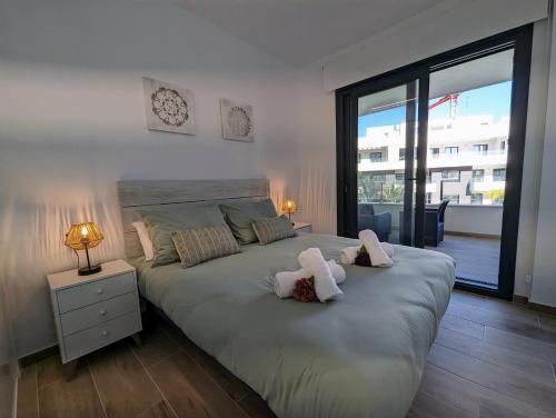 a bedroom with a large bed with two pillows on it at Poolside 2BR apartment Villamartin in Alicante