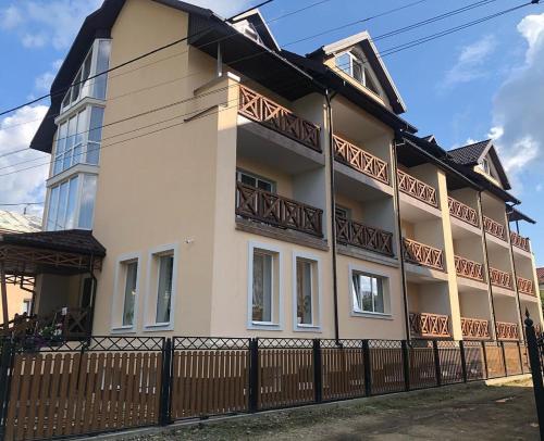 a white building with a fence in front of it at Рутенія in Skhidnitsa