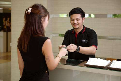 a man and a woman standing at a counter at Nantra Sukhumvit 39 in Bangkok