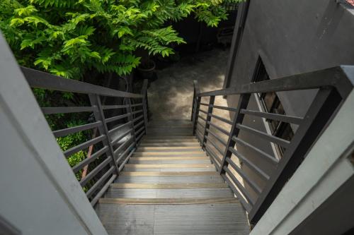a wooden staircase leading up to a building with trees at Gensan Apartment in Dulongabong