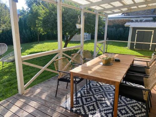 a wooden deck with a wooden table and chairs at Familien Ferienhaus im Grünen in direkter Nähe zum Nürburgring in Kempenich