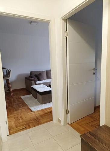 an open door to a living room with a couch at Stan na dan - apartman Istočno Sarajevo - Lukavica in Vranješ