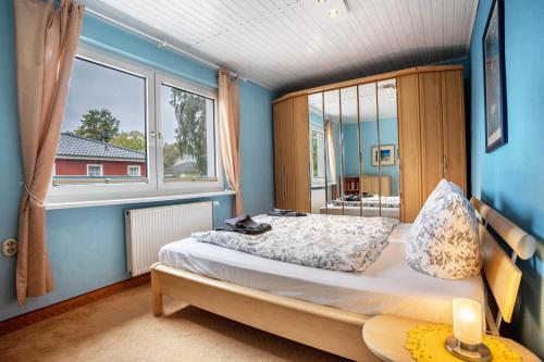 a bedroom with a bed and a large window at Prerow Am Deich - Fewo 3 in Prerow