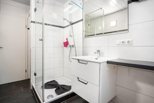 a white bathroom with a shower and a sink at Prerow Am Deich - Fewo 3 in Prerow