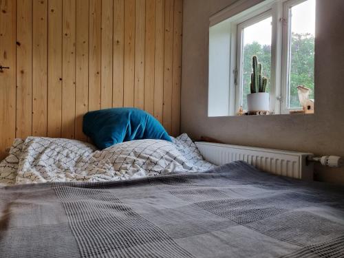 an unmade bed in a bedroom with a window at Huset i Oreby in Sakskøbing