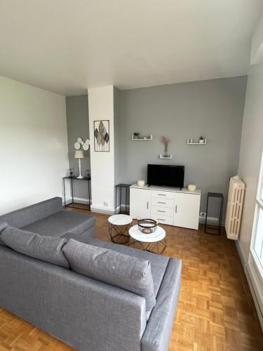 un salon avec un canapé et une télévision dans l'établissement F2 Avenue Foch, au Havre