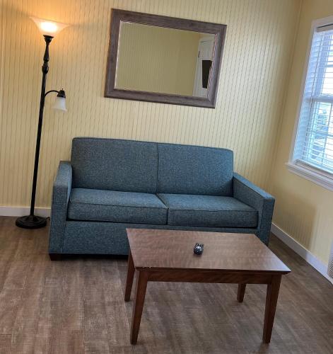 a living room with a blue couch and a coffee table at Seashell Village Resort near the beach with kitchens in Port Aransas