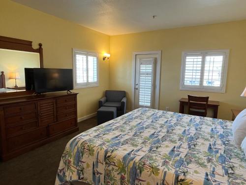 a bedroom with a bed and a flat screen tv at Seashell Village Resort near the beach with kitchens in Port Aransas