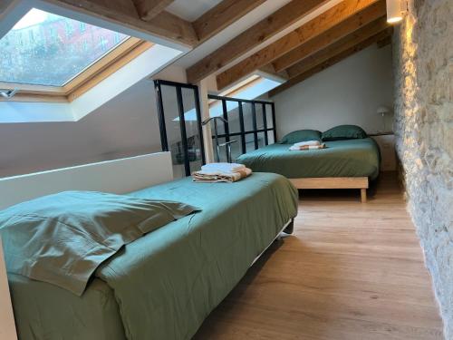 deux lits dans une chambre avec une fenêtre dans l'établissement Loft plein sud, à Paris