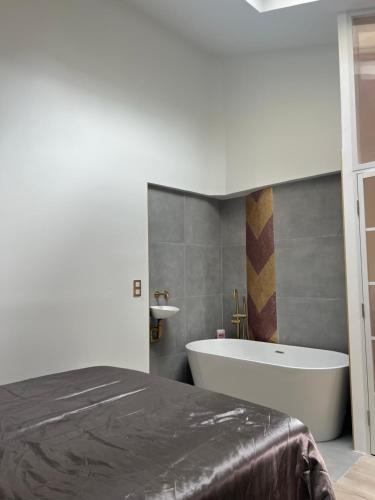 une chambre avec un lit et une baignoire dans l'établissement Loft plein sud, à Paris