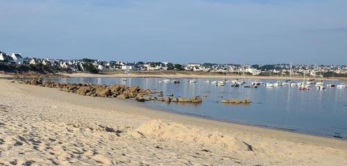 a beach with boats in the water and houses at Anatoline Audierne Appart'hôtel - Appartements vue Mer - Sea & Harbor Stay in Audierne