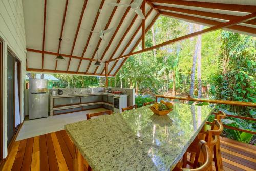 a kitchen with a table and a counter top at Casa Coki - Modern Villa Pool Steps From the Beach in Puerto Viejo