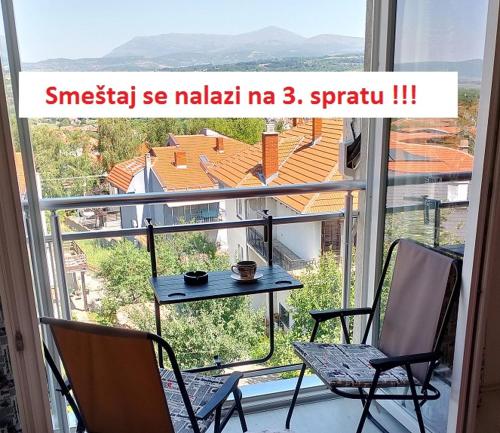 a balcony with a table and chairs in front of a window at Studio La Casa in Soko Banja
