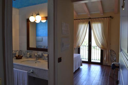 bagno con lavandino e grande specchio di Hotel Sa Contonera a Àrbatax