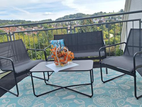 a balcony with two chairs and a table with a vase on it at Kleines Domizil am Südhang in Ortenberg