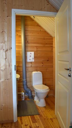a bathroom with a toilet in a wooden wall at Villa North Karelia by offerhut 25 in Onkamon Kannas