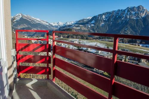a red fence with mountains in the background at Alpine Classic Hotel in Leysin