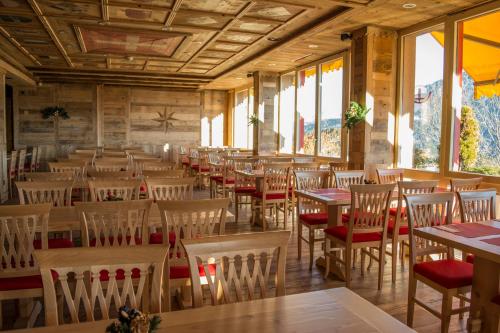 a dining room with tables and chairs and windows at Alpine Classic Hotel in Leysin
