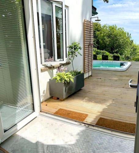 an open door to a patio with a swimming pool at Relaxing private entrance ensuite room with stunning sea view and swimspa in Saint Lawrence