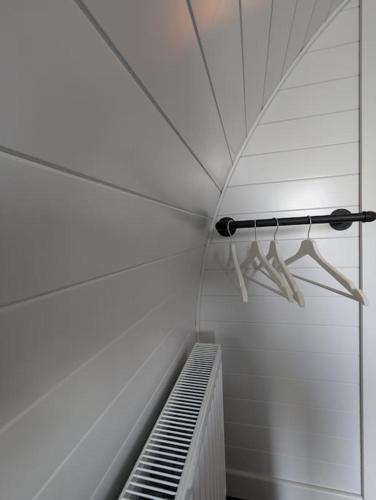 an empty room with a white wall and an umbrella at BluePigeons Pods Roag Dunvegan in Lonmore