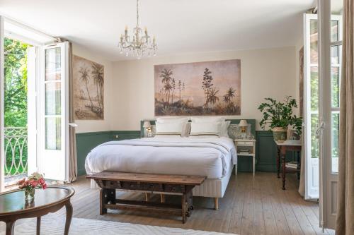 a bedroom with a large bed and a chandelier at La Maison 1680 in Couches