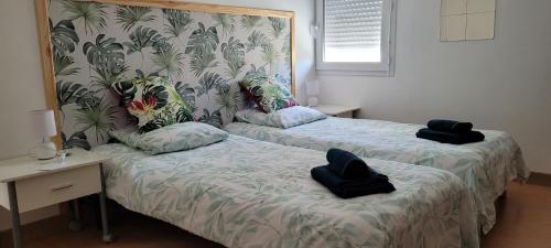 - 2 lits dans une chambre avec 2 serviettes dans l'établissement Gite de mer proche Pornic 6 personnes, à La Bernerie-en-Retz