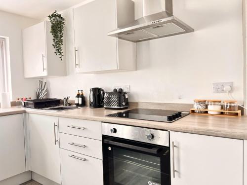 a kitchen with white cabinets and a stove top oven at Apartment 6 in Blackpool