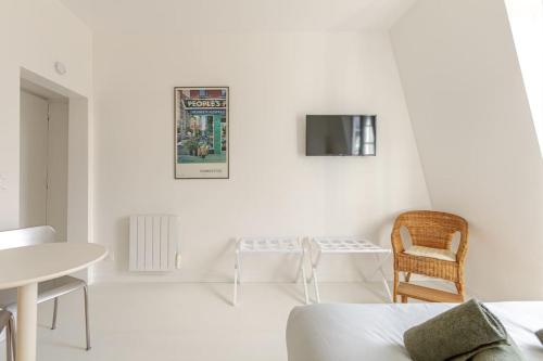 une chambre blanche avec un lit et une chaise dans l'établissement Charming Studio Ideally Located in Paris, 9th, à Paris