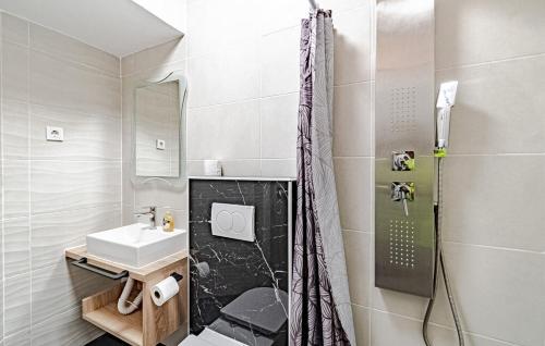 Un baño blanco con ducha y lavabo. en Kiara, en Korčula