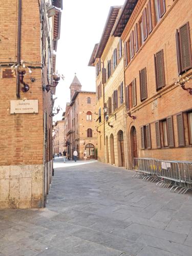 an empty street in an alley between buildings at Hotel Minerva in Siena