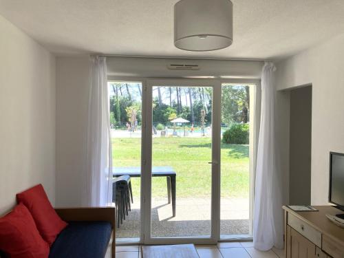 d'un salon avec une porte coulissante en verre s'ouvrant sur une terrasse. dans l'établissement Nature - Piscine - Plage à 900m, à Ondres