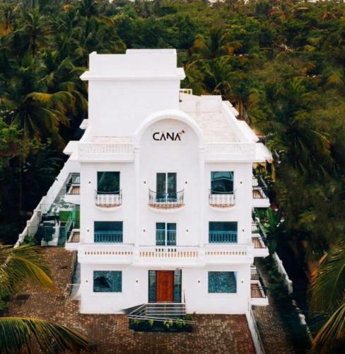 an aerial view of a white building with palm trees at Cana Boutique Stay in Porvorim
