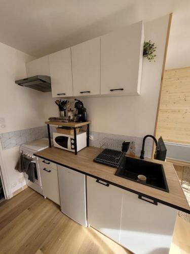 une cuisine avec des armoires blanches et un comptoir dans l'établissement Le cœur de Lans, à Lans-en-Vercors