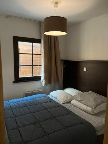 une chambre avec un lit et une grande fenêtre dans l'établissement Appartement 2 pièces Résidence les Fermes Emiguy Les Gets, aux Gets