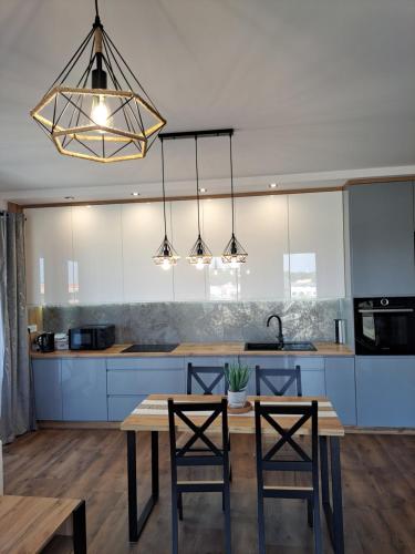 a kitchen with a wooden table and two chairs at Apartament Cegiełka Mielec in Mielec