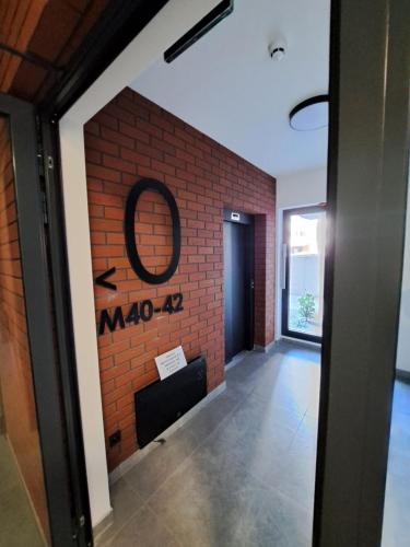 a hallway with a brick wall and a mirror at Apartament Cegiełka Mielec in Mielec