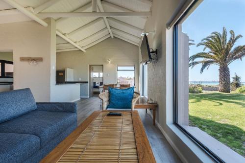 a living room with a couch and a large window at Blue Bay Lodge in Saldanha