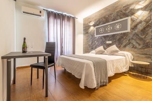 a bedroom with a bed and a table and a table and chairs at Doña Norma in Cáceres