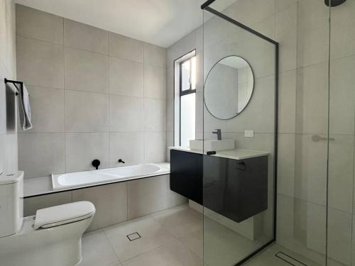 a bathroom with a toilet and a sink and a mirror at Sunny and Quiet Townhouse in Wayville